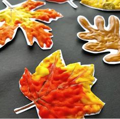 fall leaves made out of melted paint on a black tablecloth with text overlay that reads, autumn leaf crafts for kids