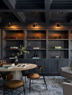 a living room filled with furniture and bookshelves next to a dining room table