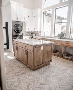 a kitchen with an island in the middle and lots of cabinets on either side of it