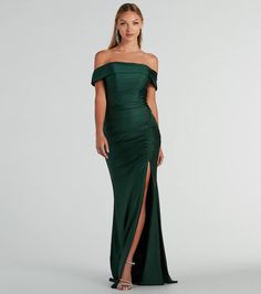 a woman in a long green dress with an off the shoulder top and side slit