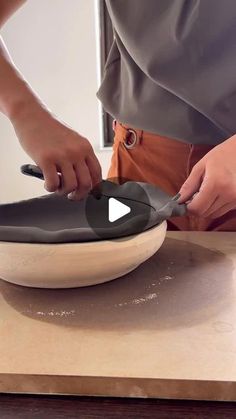 a person using a knife to cut something in a bowl