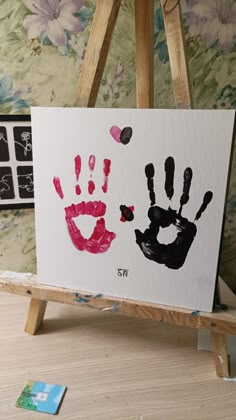 an easel with two hand prints on it