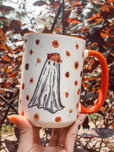 a hand holding a coffee mug with an image of a woman's dress on it