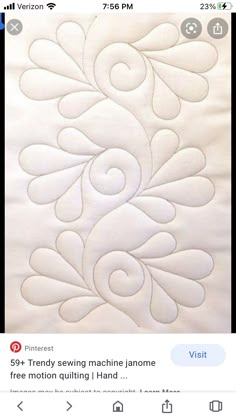 a close up of a white quilt with an intricate design on the front and back