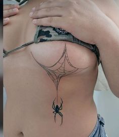 a woman's back with a spider tattoo on her lower body and the upper part of her stomach