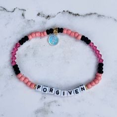 a pink and black beaded bracelet with the word for given written on it in small letters