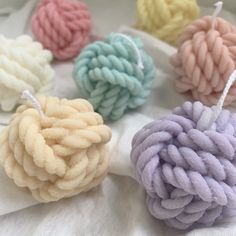 four balls of yarn sitting on top of a white cloth