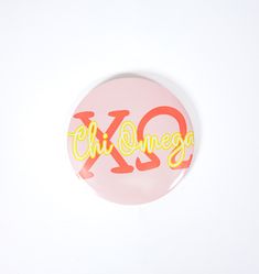 a button with the word chi dinega written in yellow and orange ink on it