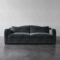 a gray couch sitting on top of a cement floor