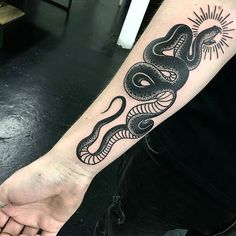 a black and white snake tattoo on the arm