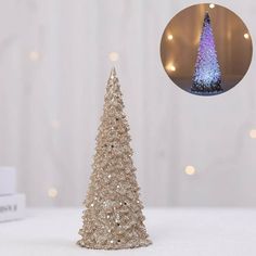 a small glitter christmas tree next to a white box with lights on it and a photo of the top