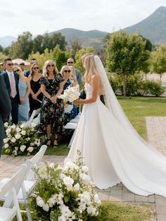 the bride and groom are getting married in front of an outdoor ceremony with white flowers