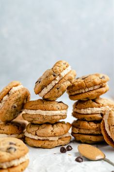 chocolate chip cookies stacked on top of each other with one cookie in the middle and more cookies scattered around