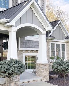 the front entrance to a house with stone pillars