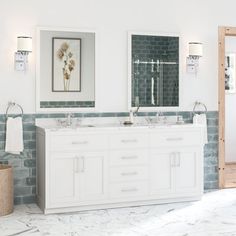 a white bathroom with two sinks and mirrors