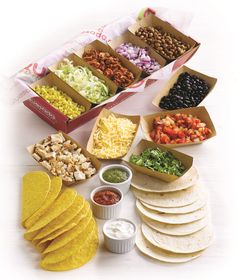 an assortment of mexican food including tortillas, salsa and beans