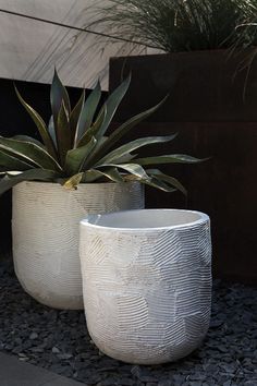 two white planters sitting next to each other