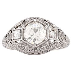 an antique style diamond ring with filigrees on the sides and center stone