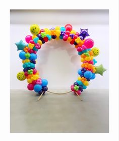 a colorful balloon arch with smiley faces and stars