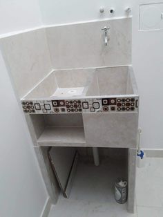 a bathroom with a sink and tiled counter top next to a toilet paper dispenser