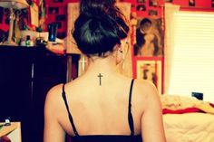 a woman with a cross tattoo on her back