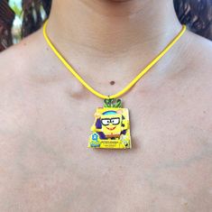 a woman wearing a yellow necklace with a cartoon character on it's front and back