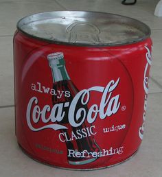 an old coca - cola can sitting on the floor