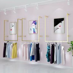 there is a pink room with clothes hanging on the rack and pictures on the wall