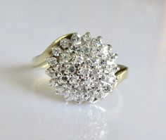 a diamond cluster ring sits on a white surface