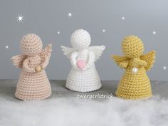 three crocheted angel figurines sitting next to each other