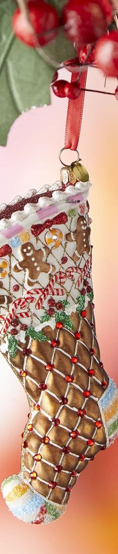 a christmas ornament hanging from a tree with candy canes and holly leaves