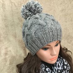 a mannequin head wearing a gray hat with a pom - pom