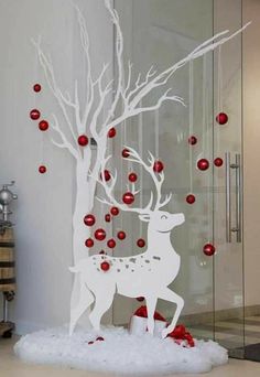 a paper cut out of a deer with red balls hanging from it's antlers