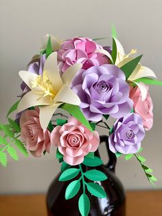 a vase filled with paper flowers on top of a wooden table