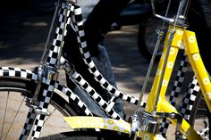 a yellow and black checkered bicycle parked on the street