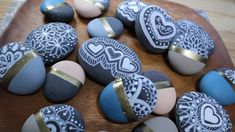 some rocks with hearts painted on them sitting on a wooden plate