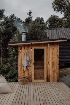 the outside of a wooden shed with towels hanging on it