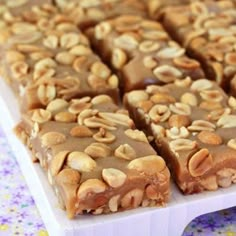 a close up of a piece of food on a white plate with nuts and chocolate