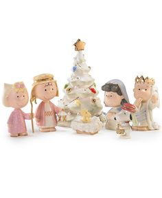 a group of figurines sitting next to each other near a small christmas tree