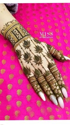 the hand is decorated with gold and white designs on it's fingers, which are accented with jewels