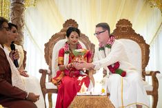 a man and woman sitting on a chair in front of a cake