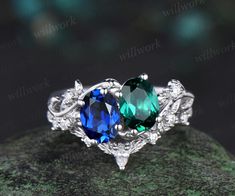 two blue and green gems are on top of each other in an intricately designed ring