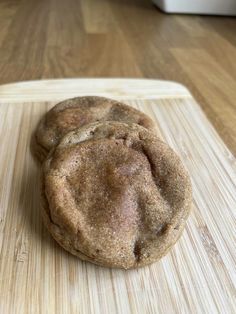 two cookies sitting on top of a wooden cutting board