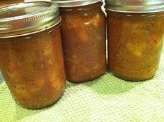 three jars filled with food sitting on top of a table