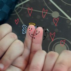 someone has drawn an angel on their thumb with hearts around them and the fingers are pink