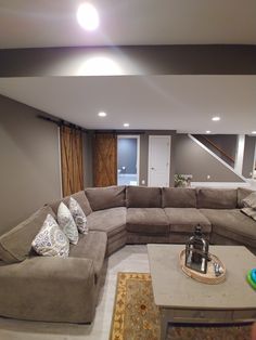 a living room filled with lots of furniture and pillows on top of the couches