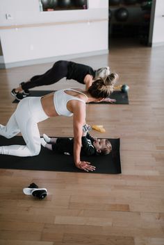 two women are doing yoga on their mats