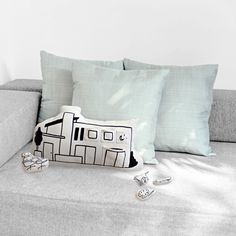 a couch with some pillows on top of it next to a pair of cuff links