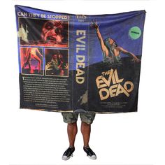 the evil dead movie poster is held up by a man with his arms in the air