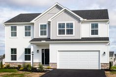 a two story house with white siding and black roof